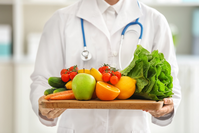 doctor holding tray of fruit and vegetables